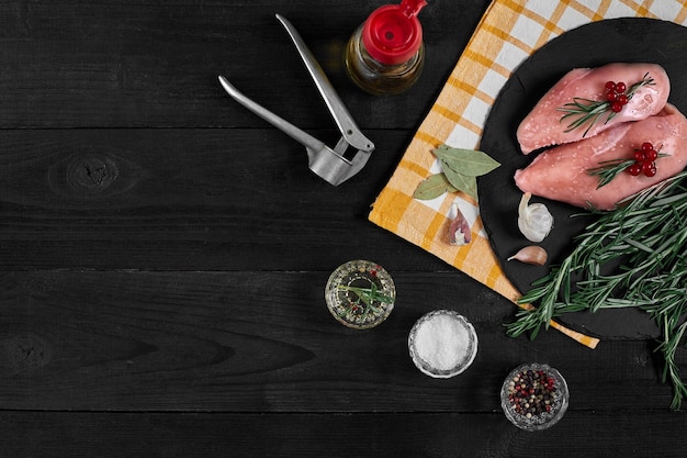 黒いスレートテーブルに調理材料を入れた生の鶏ササミ食品の背景上面図コピースペース静物フラットレイ