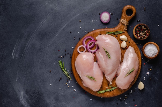 Photo raw chicken fillet with spices and herbs, top view.