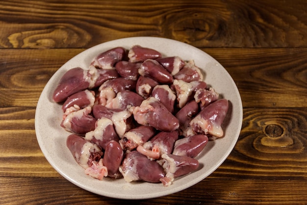 Photo raw chicken hearts on wooden table