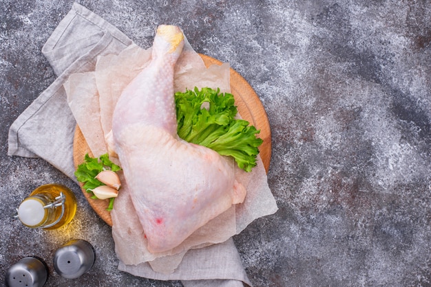 Raw chicken leg on cutting board