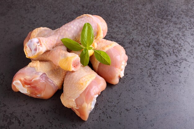 Raw chicken legs in a black background