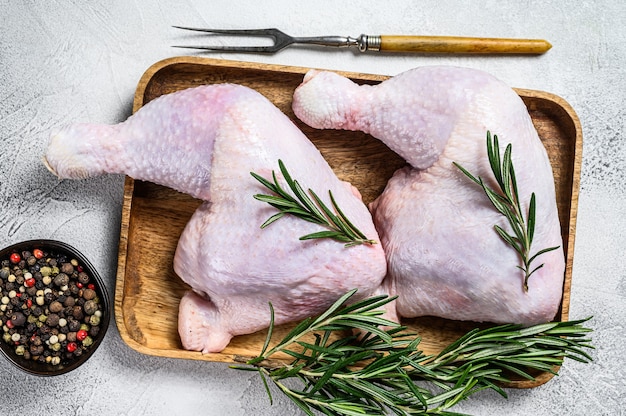 Raw chicken legs on a cutting board