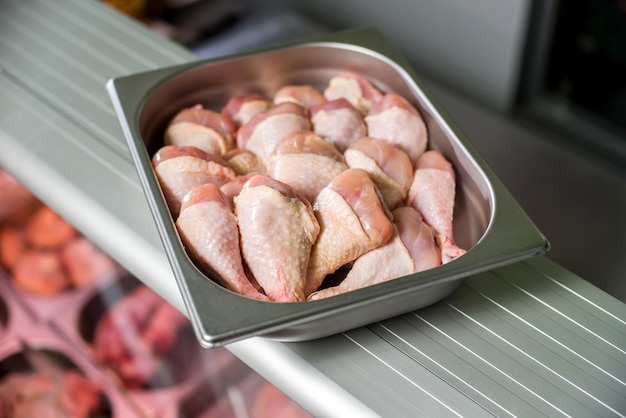 Raw chicken legs in a deep iron tray