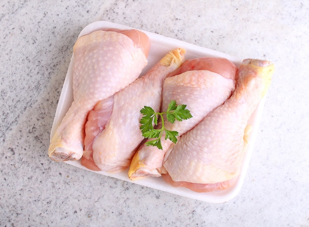 Raw chicken legs in white packaging