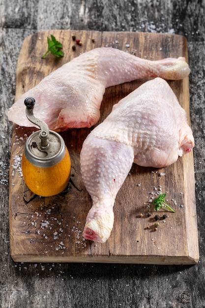 茶色にスパイスと塩を添えた生の鶏の脚。上からの眺め。