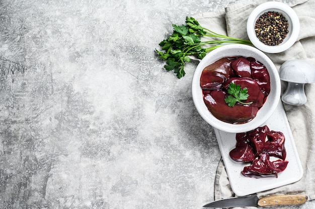 Raw chicken liver in a bowl. Top view. Copyspace background