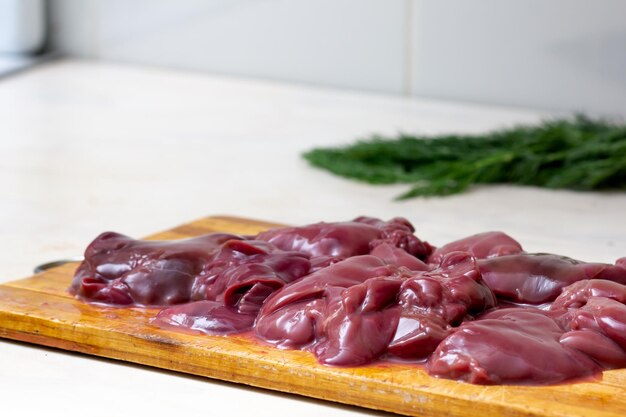 Raw chicken liver on cutting board close up