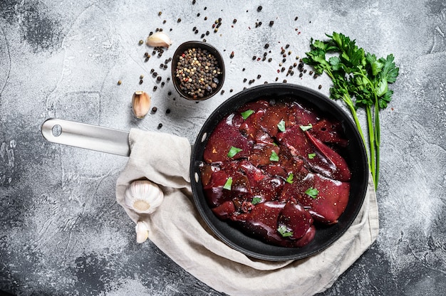 Raw chicken liver in a frying pan. Top view