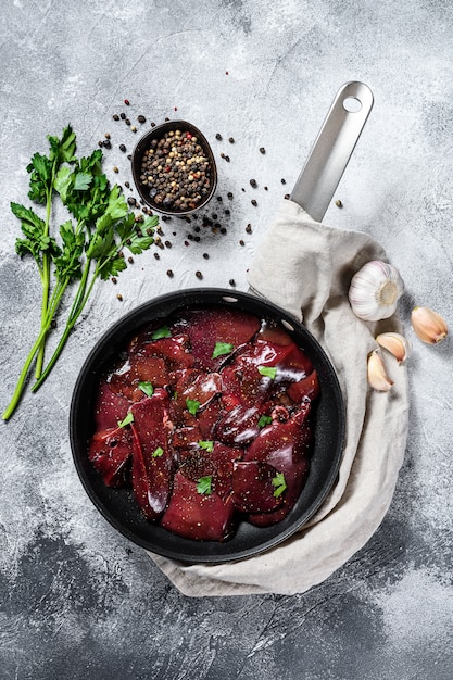 Raw chicken liver in a frying pan. Top view