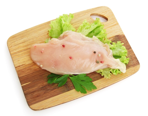 Foto carne di pollo cruda sul tagliere isolato su bianco