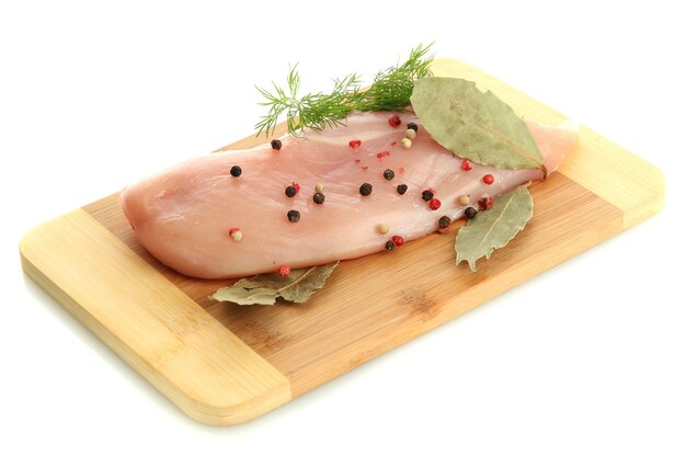 Сырое куриное мясо на разделочной доске, на белом