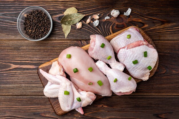 Raw chicken meat on dark wooden table.