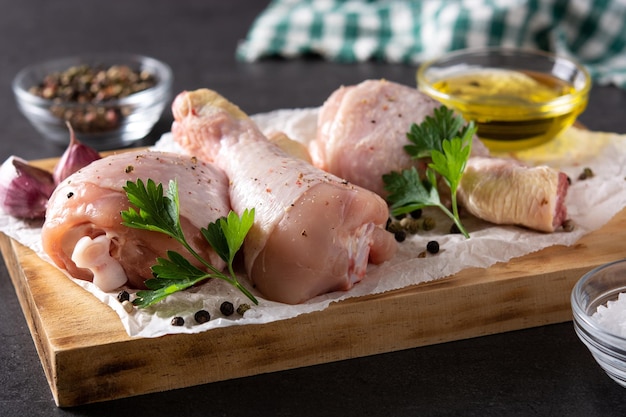 Cosce di carne di pollo cruda con spezie ed erbe aromatiche