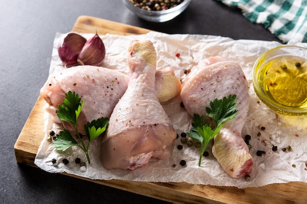 Cosce di carne di pollo cruda con spezie ed erbe aromatiche