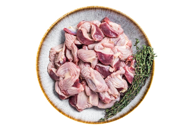 Сырые куриные желудки субпродукты в тарелке с травами, изолированные на белом фоне