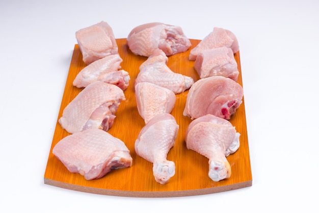 Raw chicken tender curry cut with skin arranged on wooden board