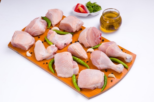 Raw chicken tender curry cut with skin arranged on wooden board