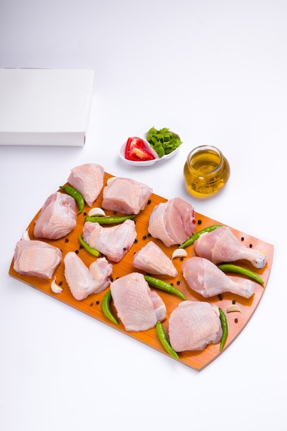 Raw chicken tender curry cut with skin arranged on wooden board