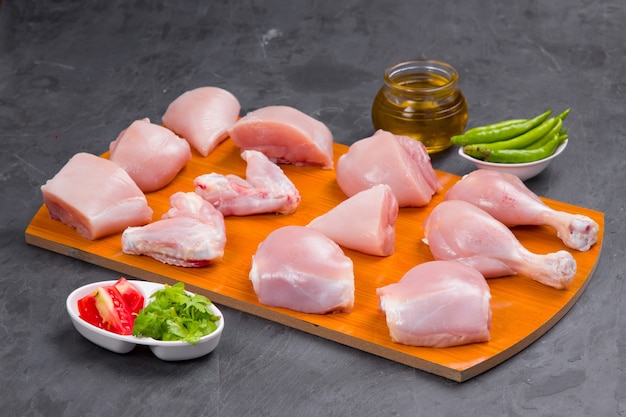 Raw chicken tender curry cut with skin arranged on wooden board