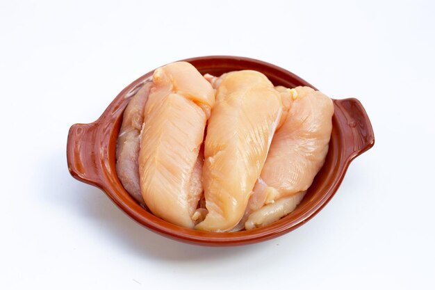 Raw chicken tenders in bowl on white background.