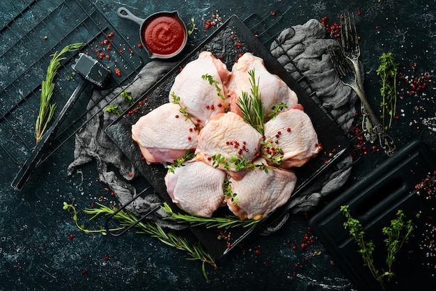Сырые куриные бедра с ингредиентами и специями на кухонном фоне Мясо Верхний вид Рустический стиль