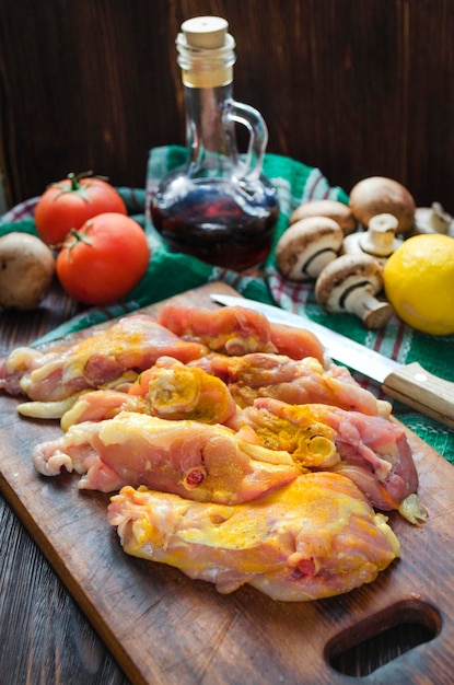 Photo raw chicken thighs with spices mushrooms and vegetables