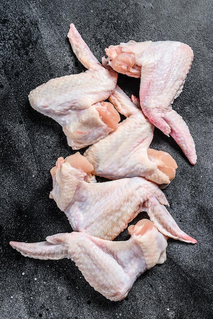 Raw chicken wings, organic poultry meat. Black background. 