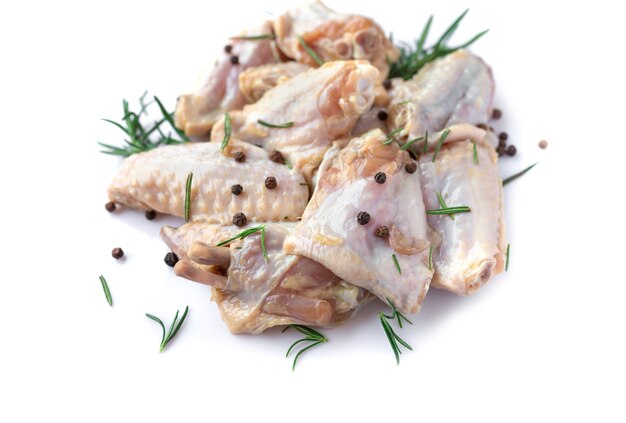 Raw chicken wings with garlic, pepperand rosemary isolated on white background