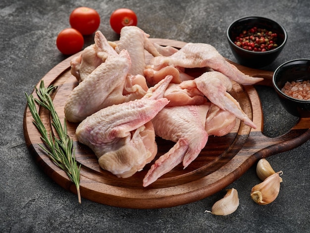 Сырые куриные крылышки с перцем и солью Мясо птицы на сером фоне