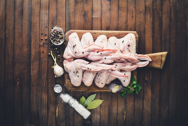 Raw chicken wings with spices. On Wooden surface. Top view.