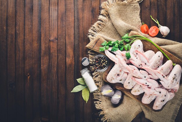 Photo raw chicken wings with spices on wooden surface top view