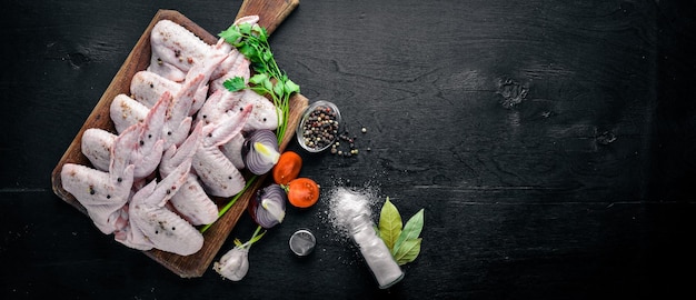 Raw chicken wings with spices On Wooden surface Top view