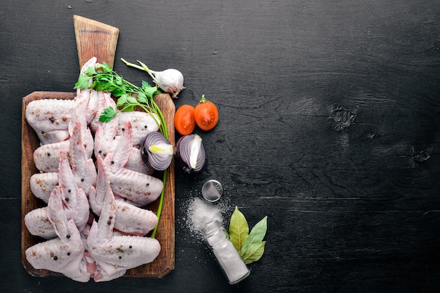 Raw chicken wings with spices On Wooden surface Top view