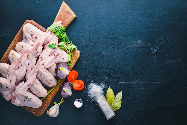 Raw chicken wings with spices On Wooden surface Top view