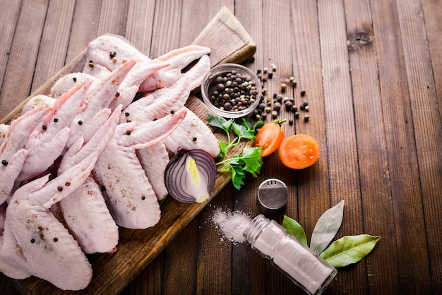 Raw chicken wings with spices On Wooden surface Top view