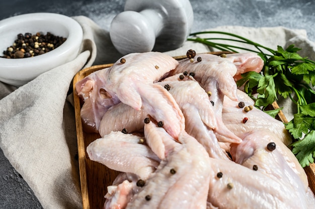 Raw chicken wings in a wooden bowl, Top view.