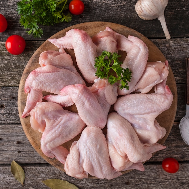 Raw chicken wings  on a wooden cutting board. Top view