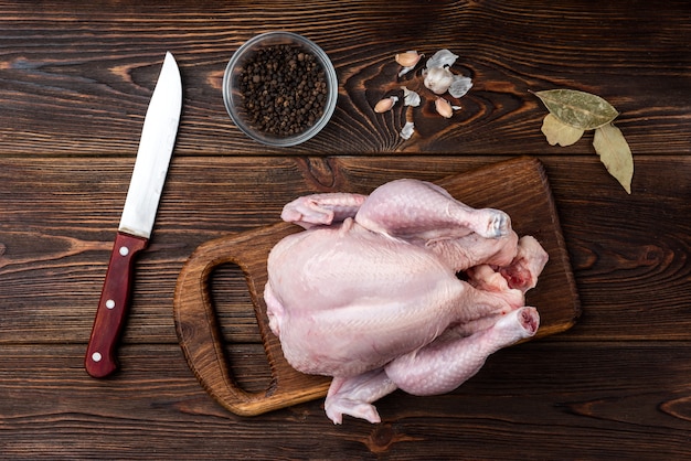 Raw chicken on wooden background with spices.