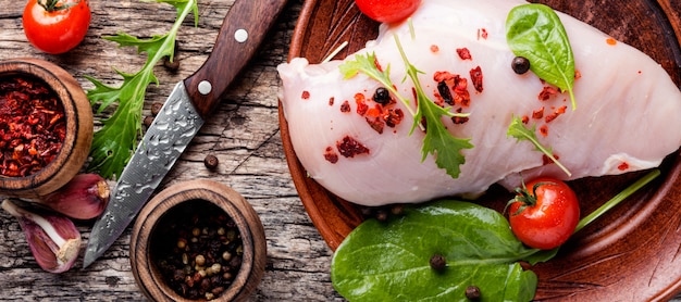 Raw chicken on wooden cutting board