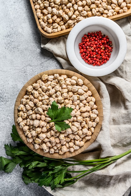 Raw Chickpeas in bowl. Nutritious food. Healthy and vegetarian food. Gray wall. Top view