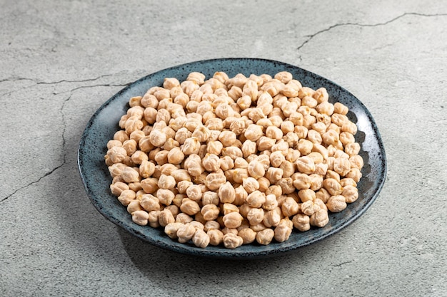 Raw chickpeas in the plate on the table