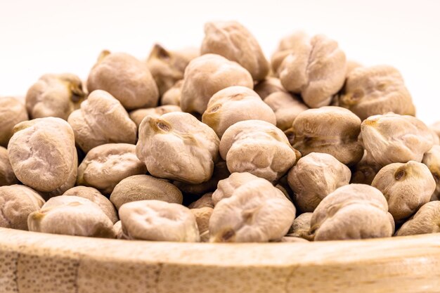 Raw chickpeas on white background isolated inside rustic wooden bowl