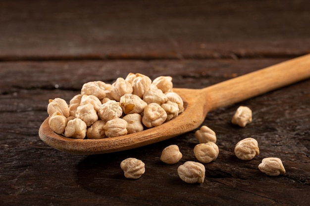 Raw chickpeas in wooden spoon