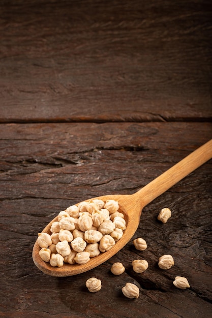 Raw chickpeas in wooden spoon