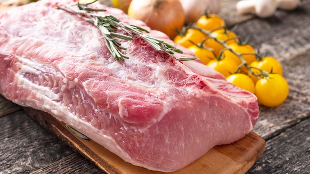 Raw chop vlees op houten snijplank met ingrediënten om te koken