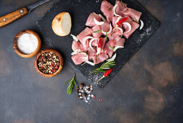 Raw chopped meat with spices on rusty background