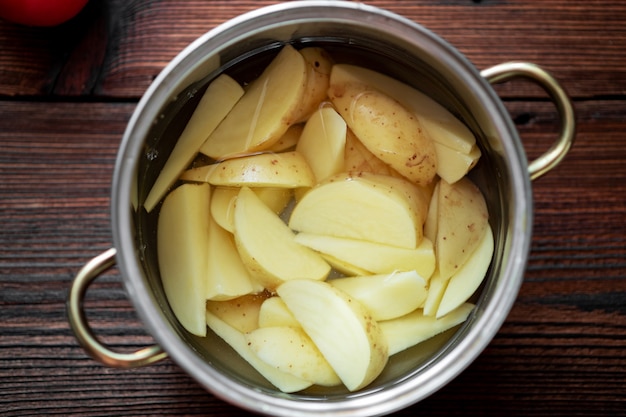 Raw chopped potatoes in a pot of water. Preparation for cooking.