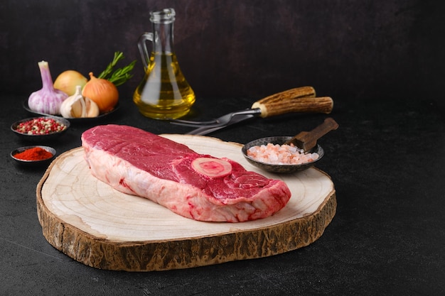 Raw chuck eye steak on wooden cutting board ready for cooking