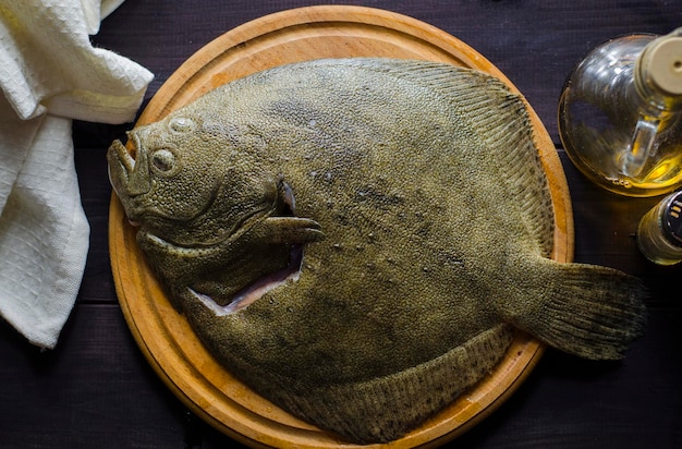 生のきれいにされたヒラメの丸ごとの魚は調理の準備ができています