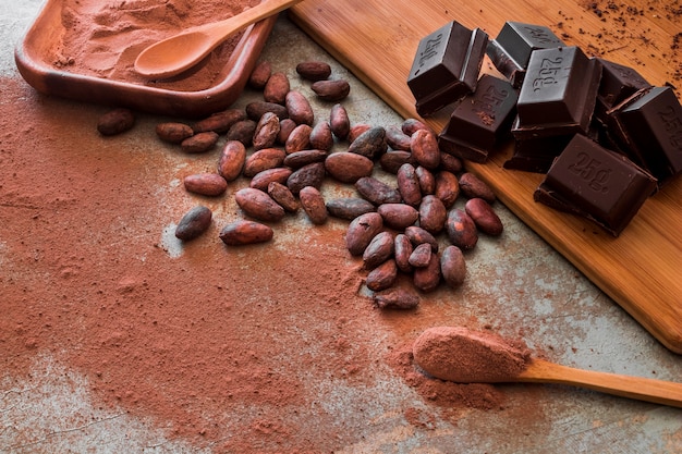 Photo raw cocoa beans and powder with chocolate cubes